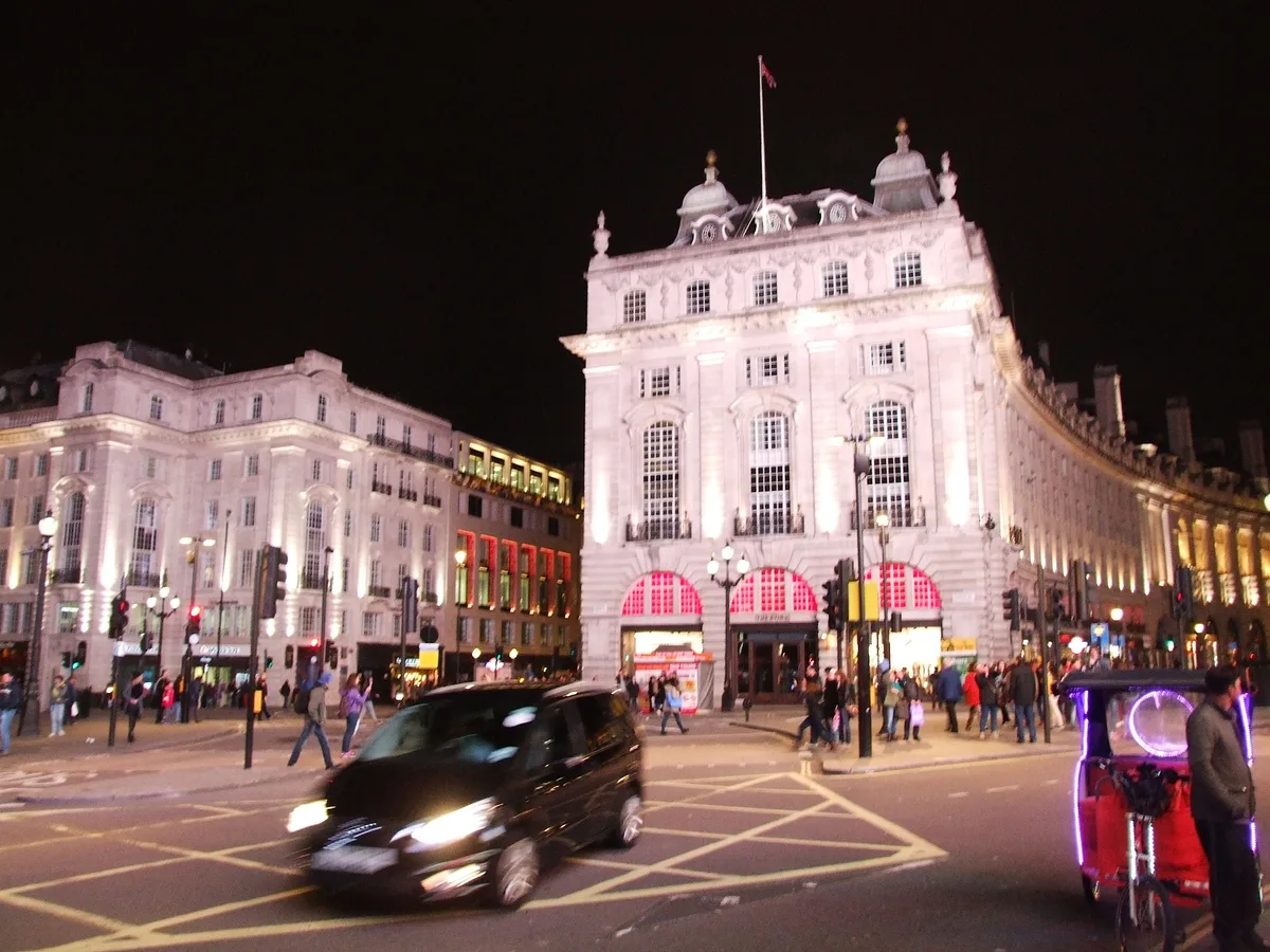 Piccadilly Circus bij nacht met de verlichte neonreclames en het Eros-standbeeld op de centrale fontein