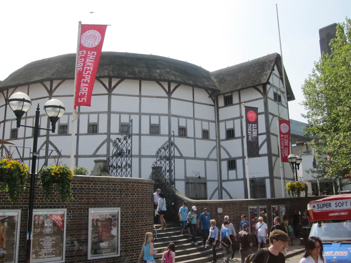 Het ronde interieur van Shakespeare's Globe Theatre met de open lucht en de vlaggen boven het toneel